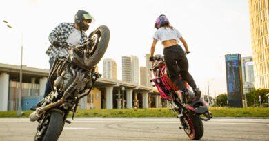 man and woman riding on motorbikes doing stunt